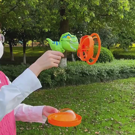 1Green dinosaur-shaped bubble gun with bubbles in a grassy outdoor setting