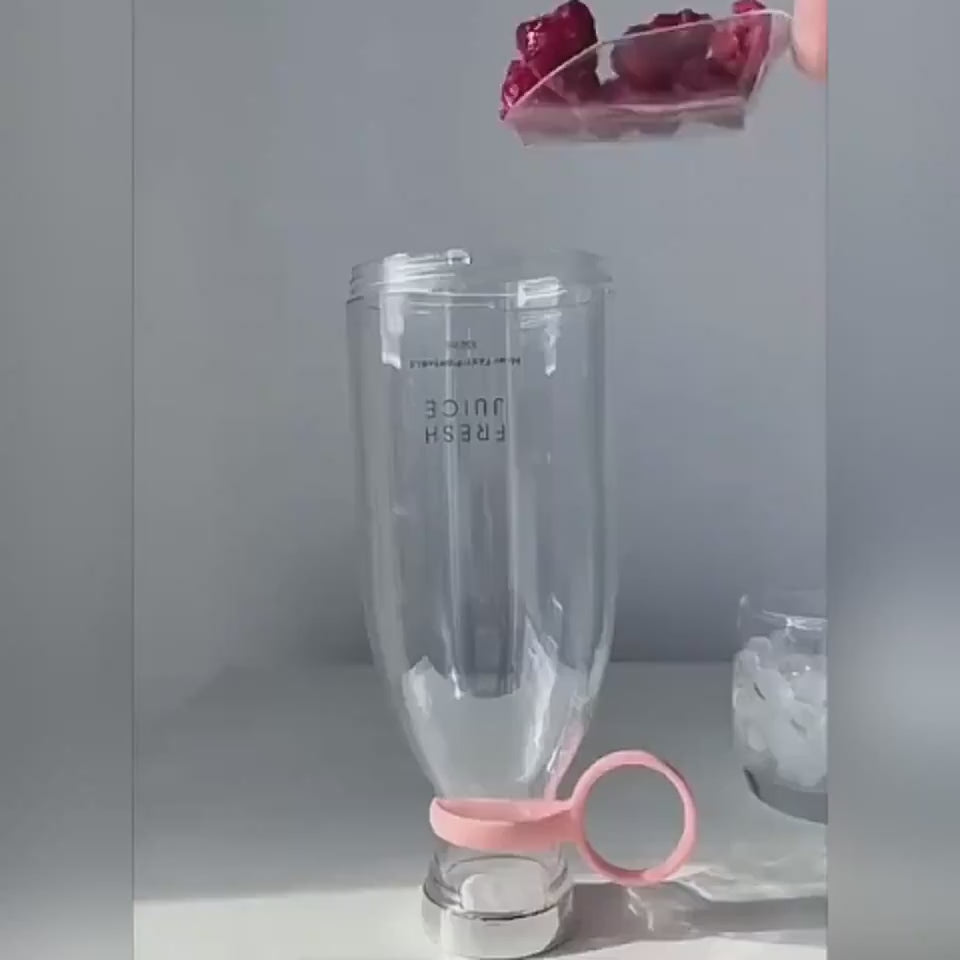 Green portable blender on a marble surface with a kitchen background BLENDER