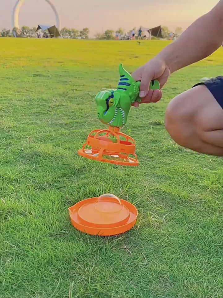 Green dinosaur-shaped bubble gun with bubbles in a grassy outdoor setting