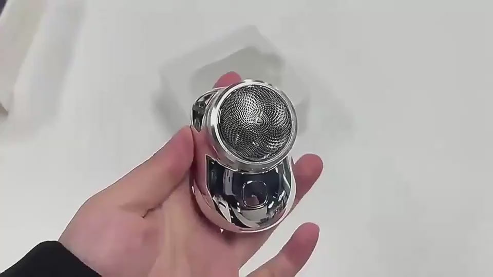 Green electric shaver on a light gray background SILVER