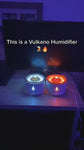 Two flameless candle lights with fire and water effects on a wooden surface.  YELLOW AND BLUE