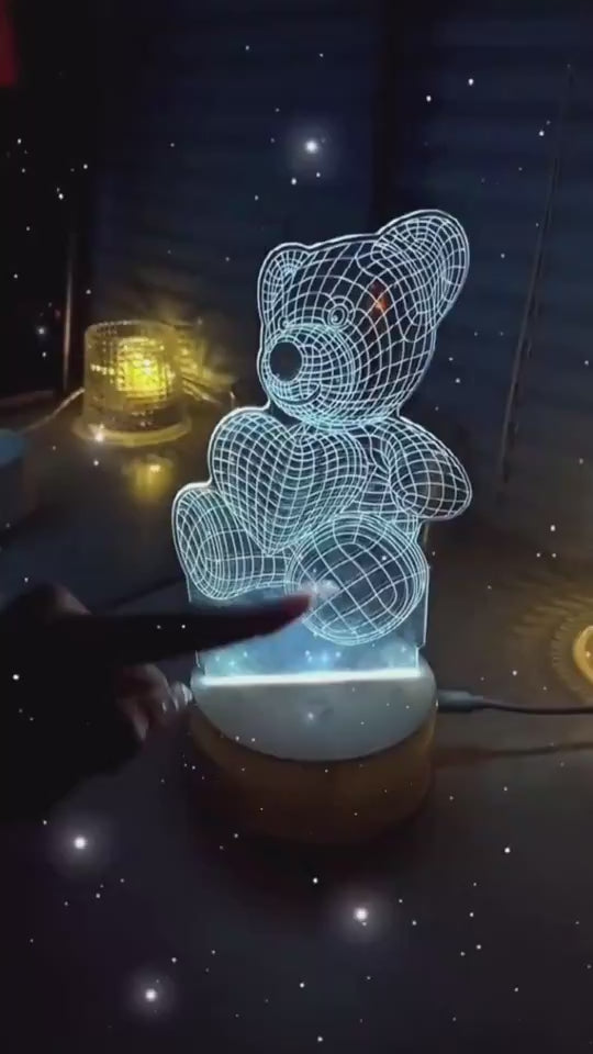 Glowing blue wireframe teddy bear lamp on a bedside table with soft lighting in the background. 3D Acrylic USB LED Night Lamp – Neon Sign

