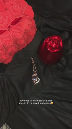 Rose gold heart-shaped pendant with a central gemstone on a soft floral background