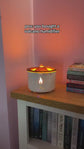 White electronic fireplace device with flames on a wooden surface
