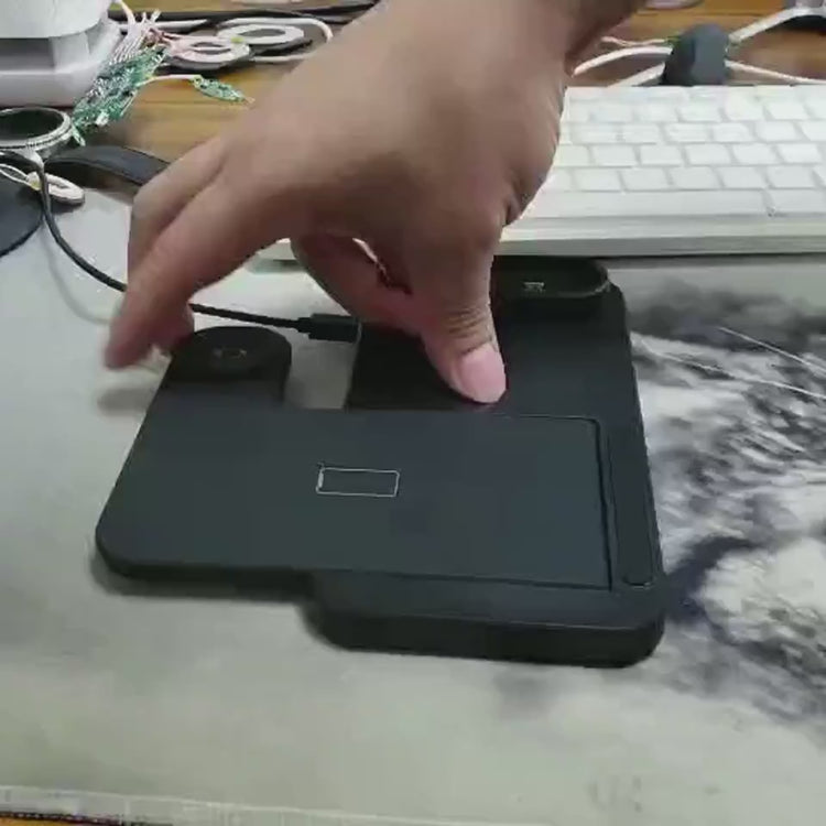 Multi-device wireless charging stand with smartphone, smartwatch, and earbuds on a desk.
