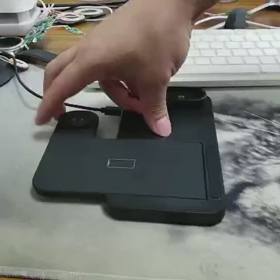 Multi-device wireless charging stand with smartphone, smartwatch, and earbuds on a desk.
