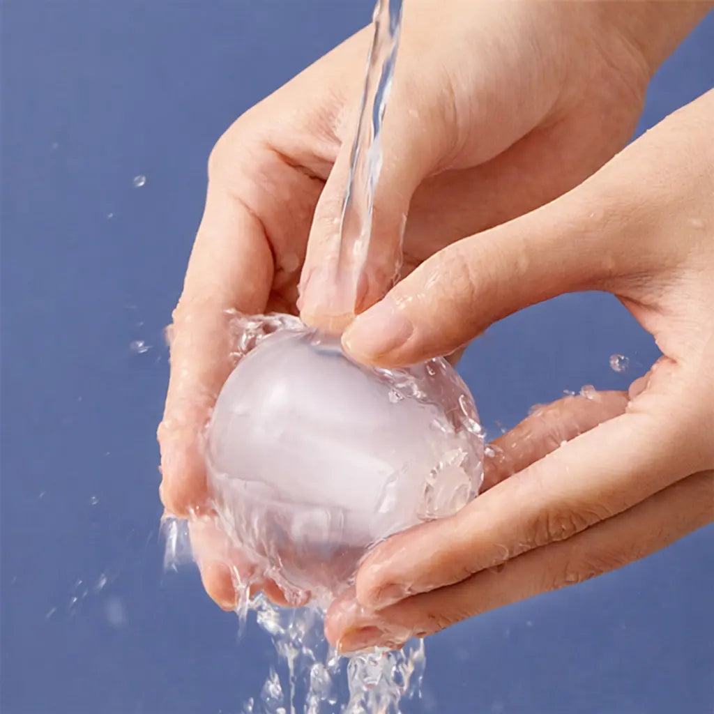 Lint roller hair remover ball being rinsed under running water by hands